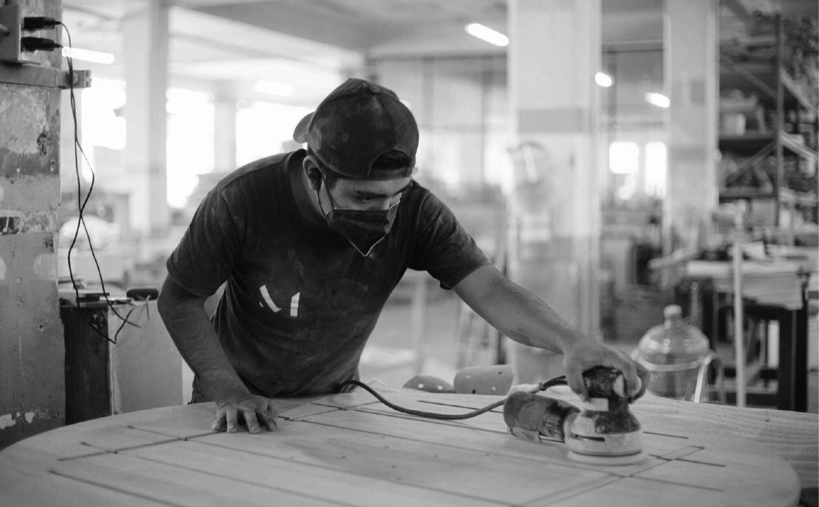 Artesano de MICMAC lijando una pieza de madera en el taller